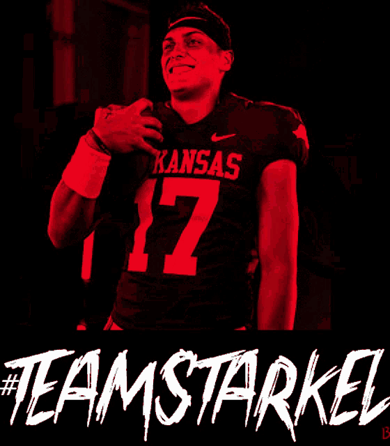 a arkansas football player is lifting a bar in red light