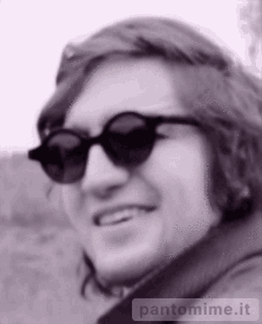 a black and white photo of a man wearing sunglasses with pantomime.it written on the bottom right