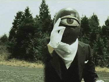 a man in a suit and white gloves with a mask on his face