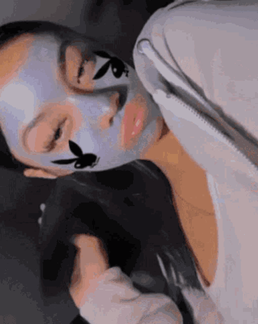 a woman with a playboy bunny face paint on her face