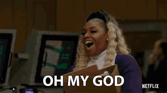 a woman in a purple sweater is holding a box and says " oh my god "