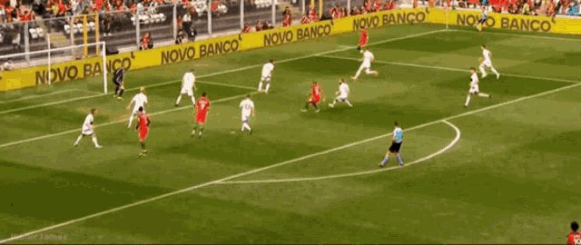 a soccer game is being played on a field with a banner that says novo banco
