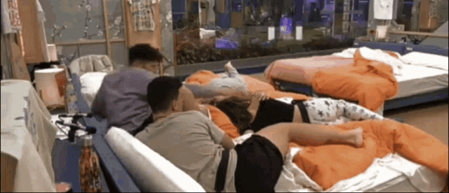 a group of people laying on a couch in a room with a sign on the wall that says ' chinese '