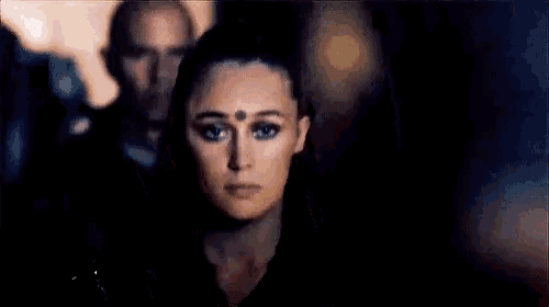 a close up of a woman 's face with a man standing behind her .