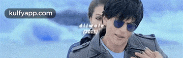 a man wearing sunglasses is standing next to a woman with the words kulfyapp.com written on the bottom
