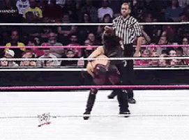 a wrestler is being lifted in the air by a referee in a ring