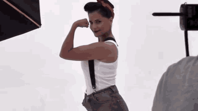 a woman flexing her muscles in front of a camera