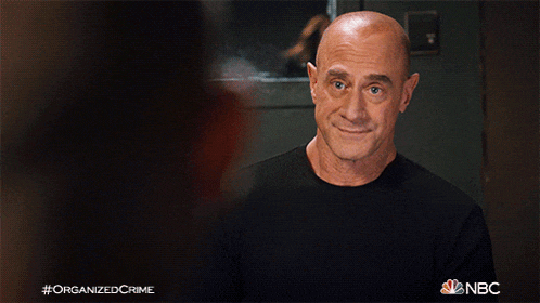 a man in a black shirt is smiling with the hashtag organizedcrime on the bottom right