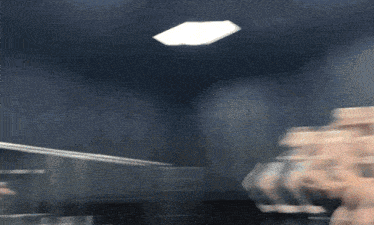 a blurry picture of a person in a dark room with a light on