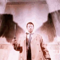 a man in a trench coat and tie is holding a gun and a flashlight .