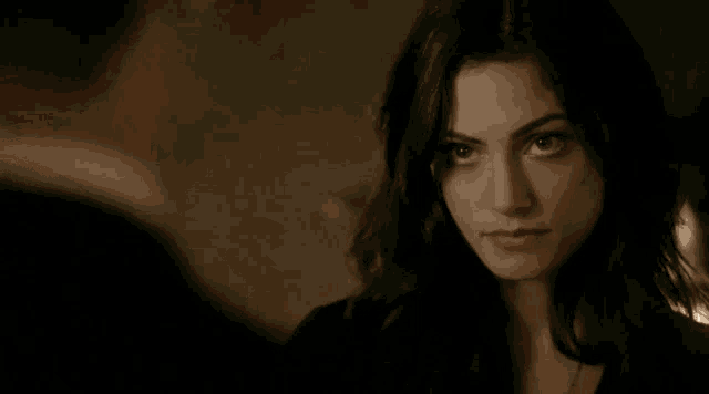 a woman with long dark hair is looking at a man