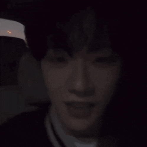 a man is smiling in the back seat of a car in the dark .