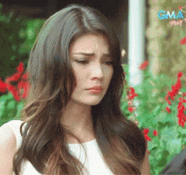 a close up of a woman 's face with flowers in the background and a gma logo