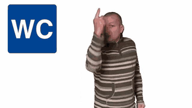a man wipes his face in front of a blue square that says wc