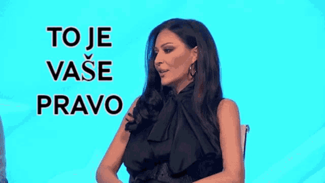 a woman in a black dress is sitting in front of a blue background with the words `` to je ваше pravo '' written on it .