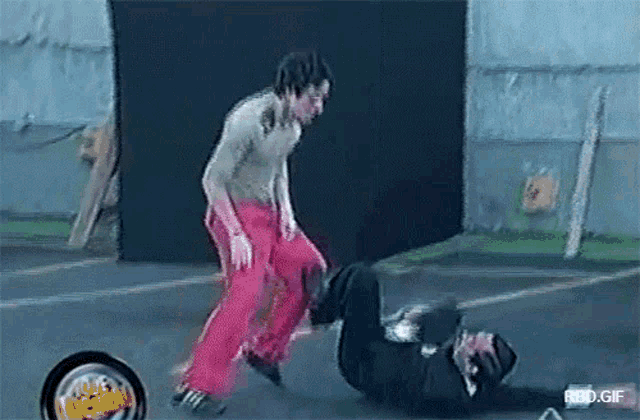 a man in red pants is kicking another man in a video game