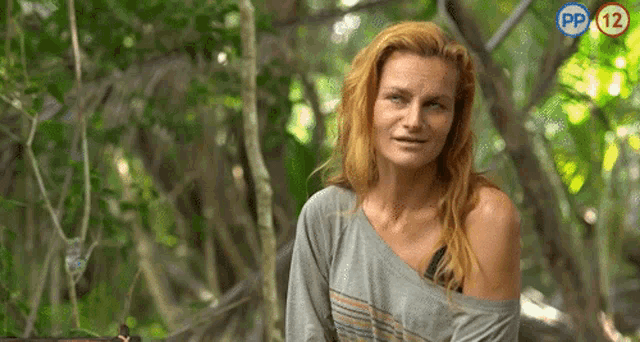 a woman in a gray shirt is sitting in the woods with pp 12 written on the bottom