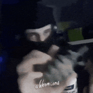 a man wearing a ski mask is holding a bottle of urine
