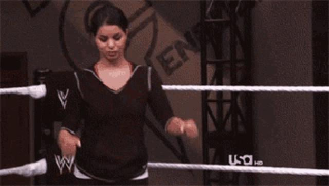 two women are standing in a wrestling ring with the word u-o on the ground