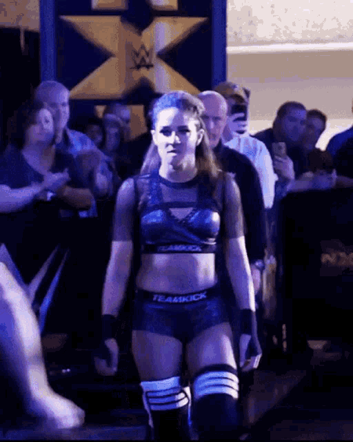 a female wrestler wearing a top that says teamkick on it
