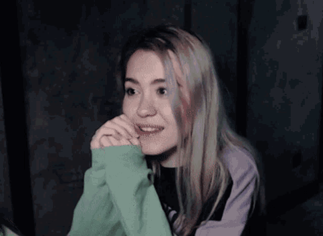 a close up of a woman 's face with a purple sweater on