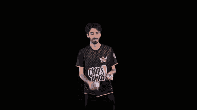 a man wearing a chips ahoy shirt is juggling