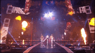 a group of wrestlers are walking down a stage with a aew logo in the corner