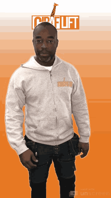 a man wearing a giraffe lift sweatshirt stands in front of a orange background