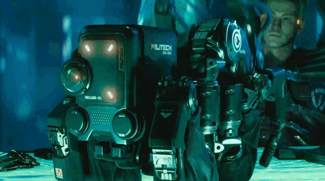 a man is kneeling next to a robot that has the number 10 on it