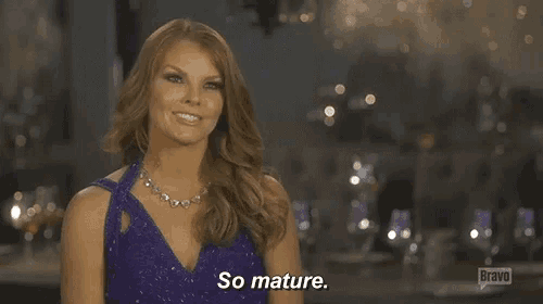 a woman in a purple dress and necklace says so mature .