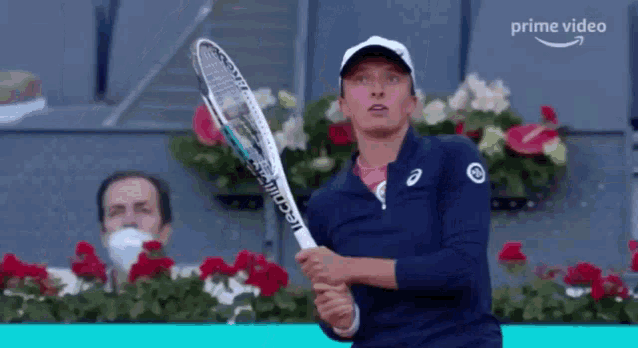 a woman is holding a tennis racquet in her hand while playing tennis .