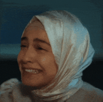a woman wearing a white hijab is smiling