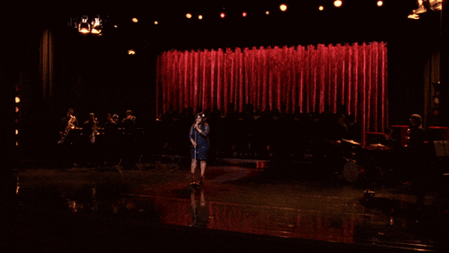 a woman singing into a microphone on a stage