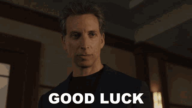 a man in a suit says " good luck " in front of him