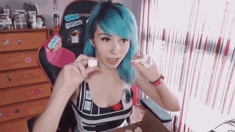 a girl with blue hair is sitting in a chair with a sticker on it that says " when dry "