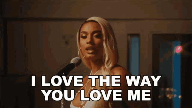a woman singing into a microphone with the words " i love the way you love me " below her
