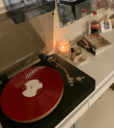 a bottle of coca-cola sits next to a record player