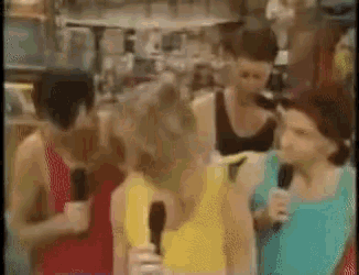 a group of people are talking into microphones in a room .