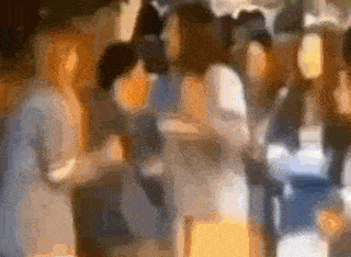 a blurry picture of a group of people standing next to each other at a party .