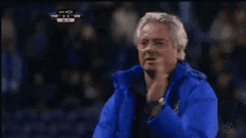a man in a blue jacket stands in front of a fox sports screen