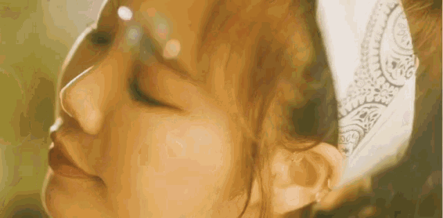 a close up of a woman 's face with a bandana around her head .