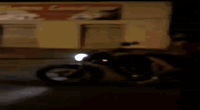 a man in a mask is riding a motorcycle down a street at night .