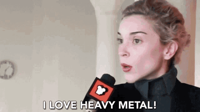 a woman is talking into a microphone and saying `` i love heavy metal ! ''