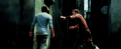 a group of people are standing next to each other in a dark alleyway .