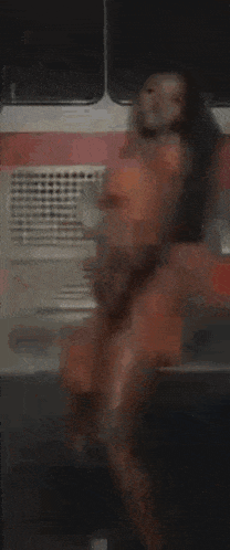 a woman in a red dress is dancing in front of a fire truck .