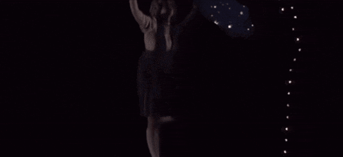 a blurred image of a person in a dark room with a christmas tree in the background .