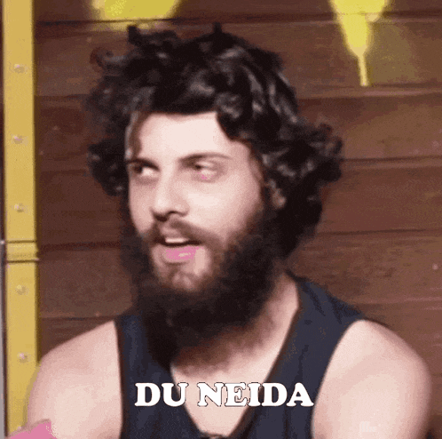 a man with a beard is wearing a black tank top and says du neida .