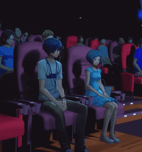 a man and a woman are sitting in a movie theater