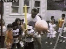 a man is holding a basketball and a baseball bat in front of a group of children ..