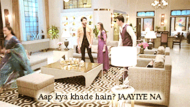 a group of people are standing in a living room with the words aap kya khade hain